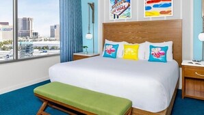 A hotel room with a large bed, a bench, a nightstand, a lamp, and a city view. - 2Bed/2Bath Deluxe Spacious Condo in Las Vegas, Complete With Margarita Mixer!! (Las Vegas)