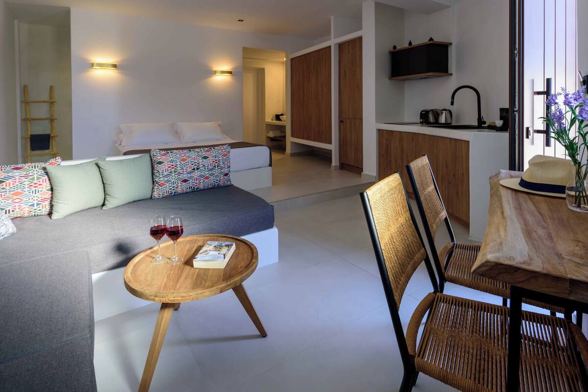 Una sala de estar moderna con un sofá, una mesa redonda de madera y sillas de mimbre.