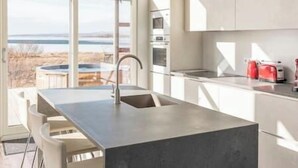 A modern kitchen with a large window, a built-in sink, and a view of the outdoors.