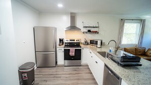 Een moderne keuken met roestvrijstalen apparatuur, een vaatwasser en een aanrecht met een afwassysteem.