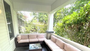 A covered porch with a sectional sofa and a coffee table. - Walk to Duke Campus!  3 Bedroom in Trinity Park! (Durham)