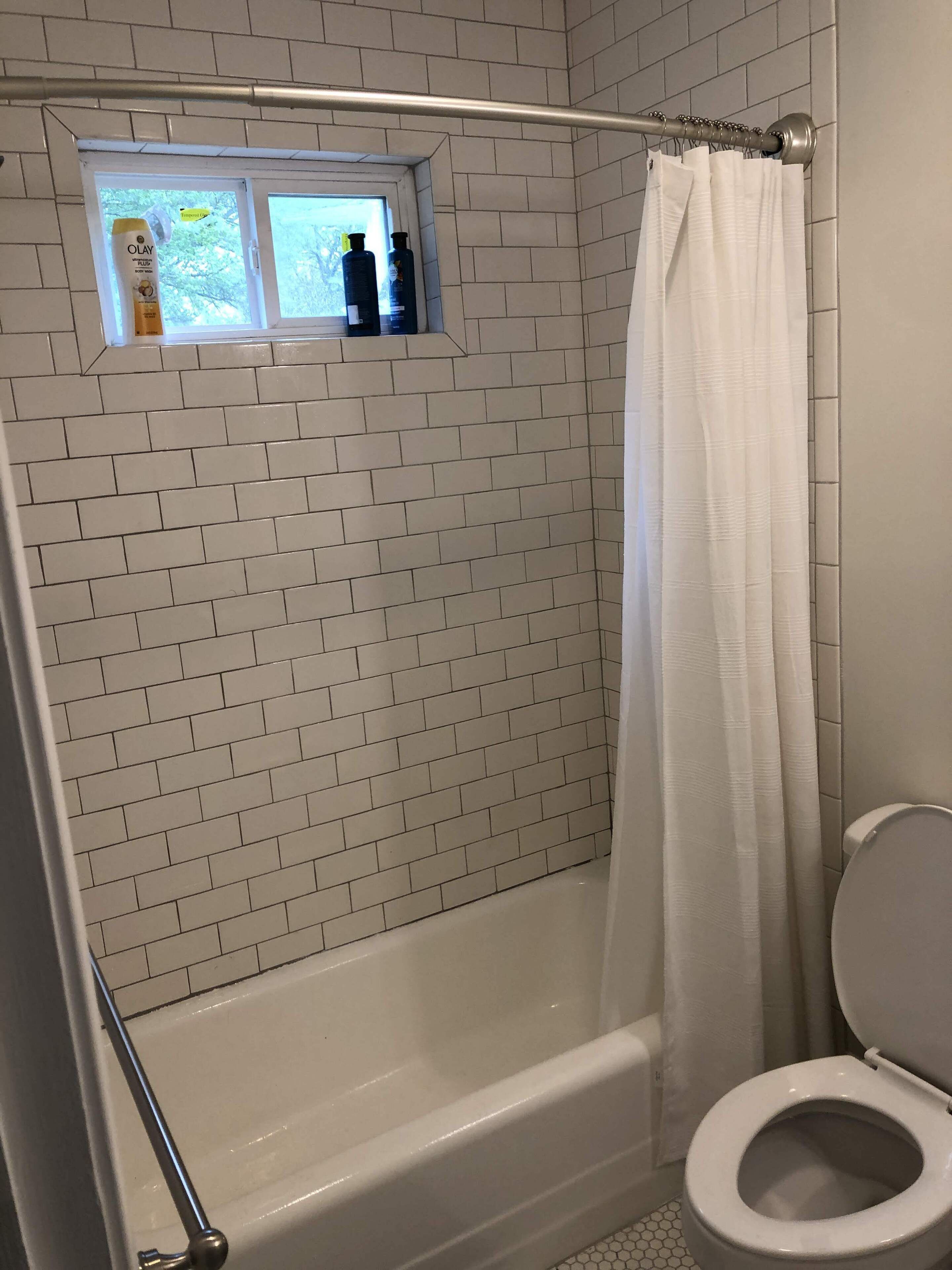 A bathroom with a white bathtub, a white toilet, and a shower curtain.