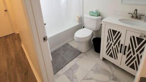 Een badkamer met een douche, toilet en wastafel.