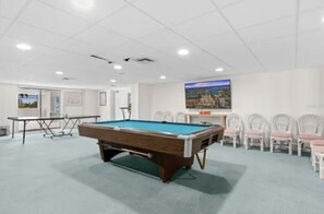 Enjoy a game of pool in this spacious room featuring a pool table and comfortable seating.