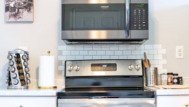 Een moderne keuken met een RVS magnetron, oven en koffieapparaat.