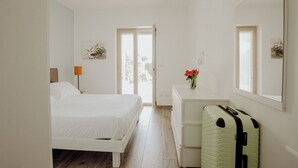 Ein Schlafzimmer mit Bett, Kommode und Koffer.