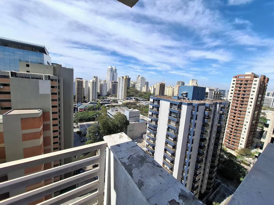 Un edificio de gran altura con varios balcones y vistas a un paisaje urbano.