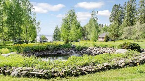 A serene garden with a pond, surrounded by lush greenery and trees. - Ateljee by Interhome (Rääkkylä)