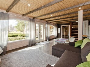 A spacious living room with a large window, a sofa, and a rug.