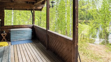 Puinen terassi, jolta avautuu näkymä puilla ympäröidylle järvelle.