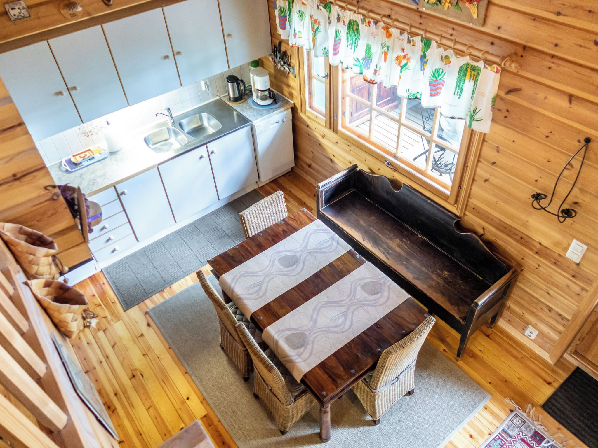 Una cocina funcional con lavamanos, estufa y comedor con mesa y sillas.