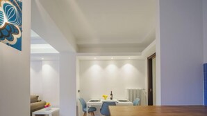 Una sala de estar moderna con un sofá, una mesa de centro y un comedor con una mesa y sillas.
