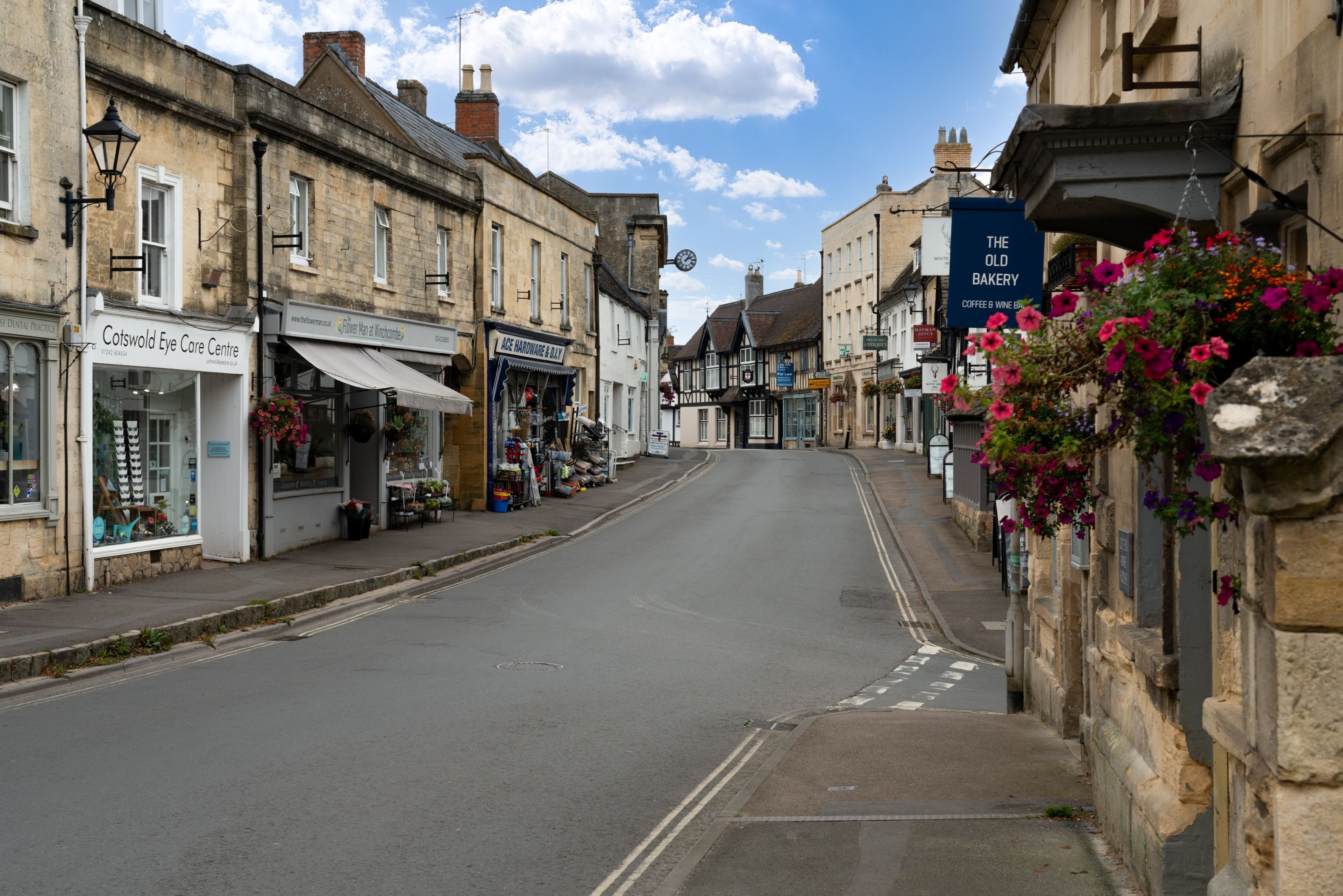 A street with shops, including a pharmacy and a bakery.
