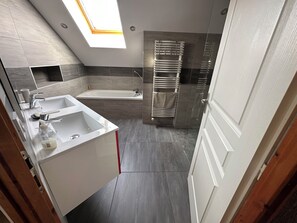Enjoy a spacious bathroom with a bathtub, double vanity, and towel rack.