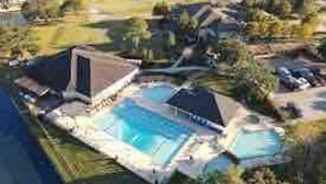 Una propiedad residencial con piscina, terraza techada y jardín ajardinado.