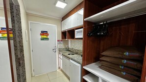 Cuina amb microones, armaris i sòl de rajola.