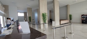 Ein Empfangsbereich mit Theke, Computern und einer Sitzecke mit einer Couch.