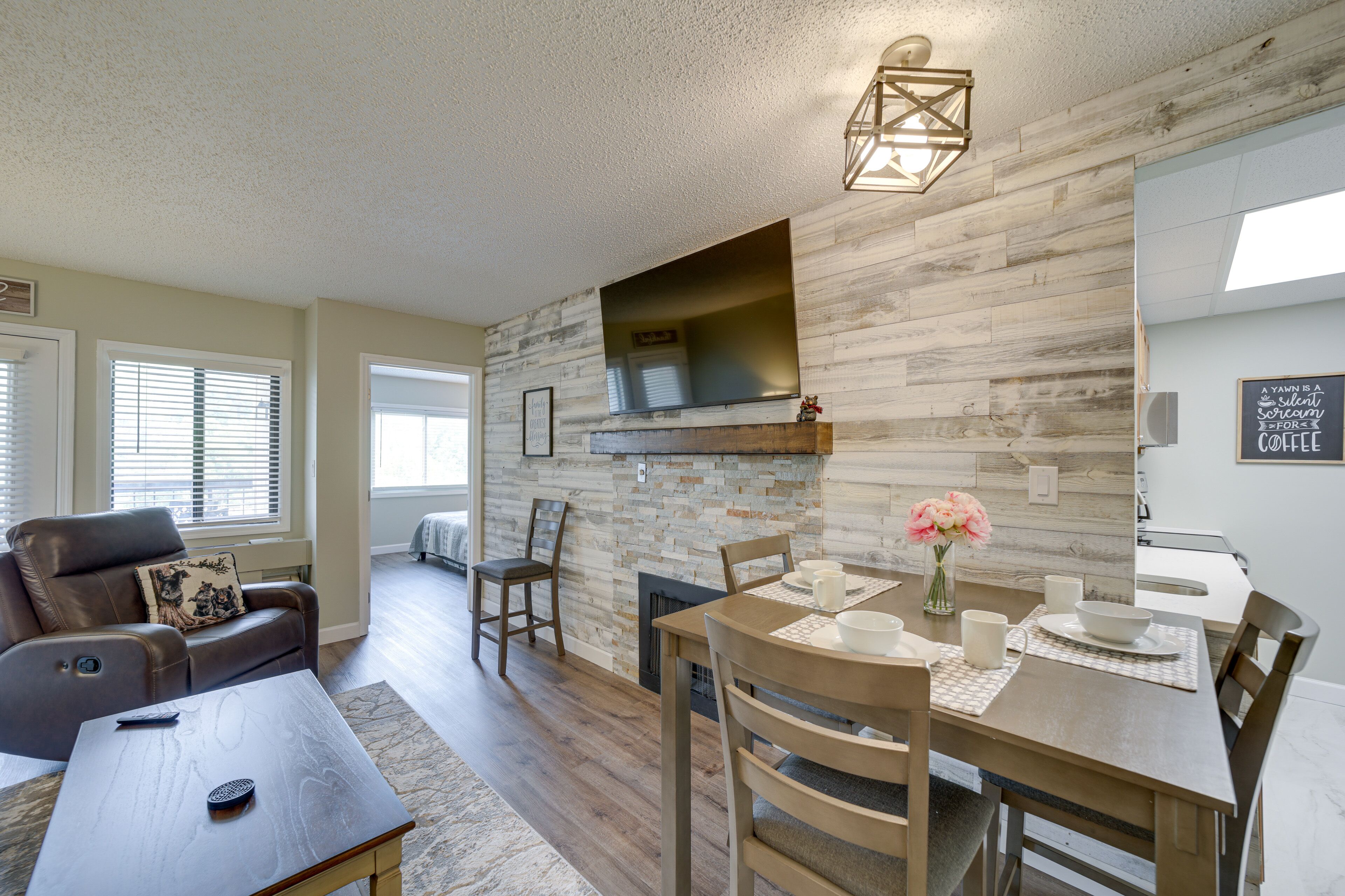 A modern living room with a fireplace, a dining area with a wooden table, and a comfortable seating area with a leather sofa.