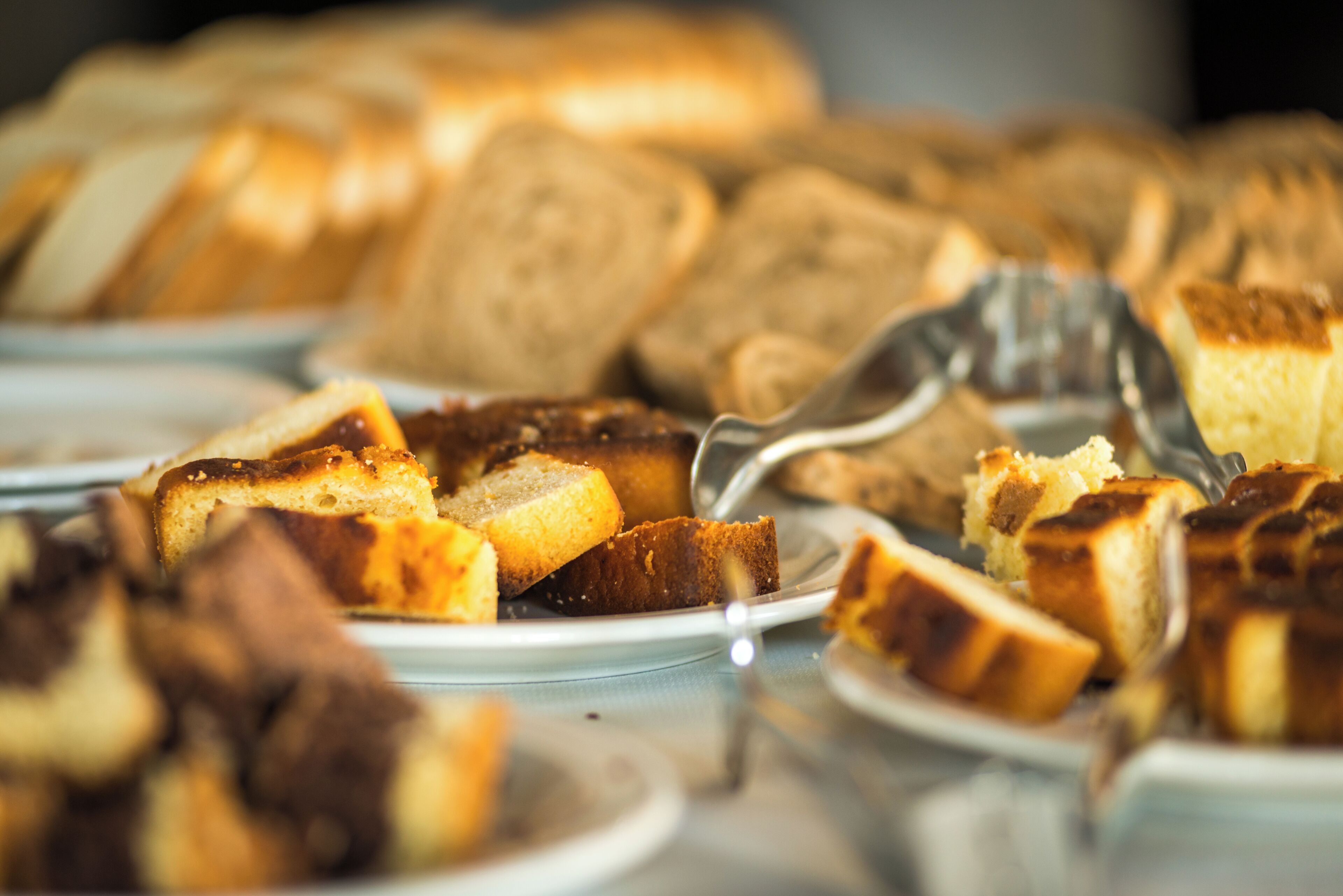 A variety of bread and pastries on plates.