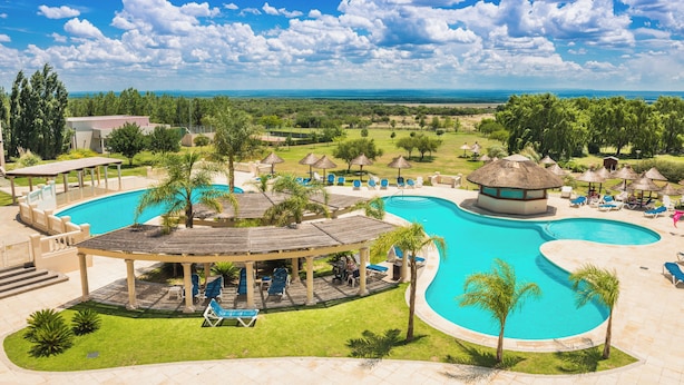 Un complexe hôtelier doté d’une grande piscine, de chaises longues et d’un belvédère.