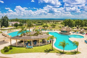 A resort with a large swimming pool, lounge chairs, and a gazebo. - Howard Johnson Hotel & Convention Center by Wyndham, Merlo (Merlo)