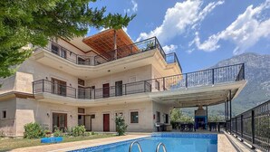Un bâtiment à deux étages doté d’une piscine, d’un espace extérieur aménagé et offrant une vue sur la montagne.
