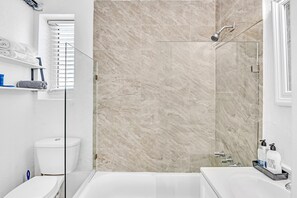 Departamento básico, 1 cama Queen size y sofá cama | Baño | Regadera, toallas, jabón, shampoo 