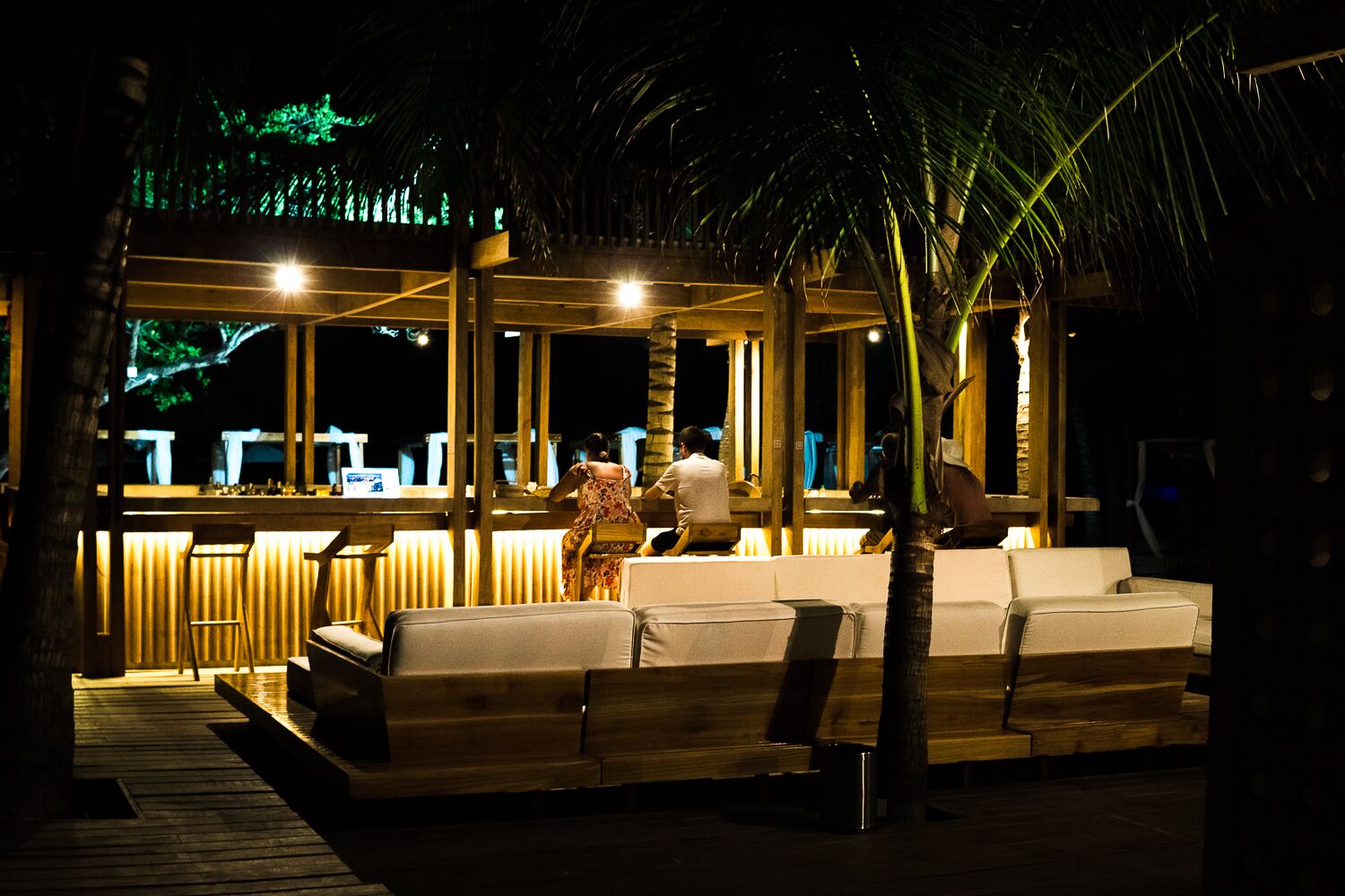 An outdoor seating area with a bar and wooden deck.