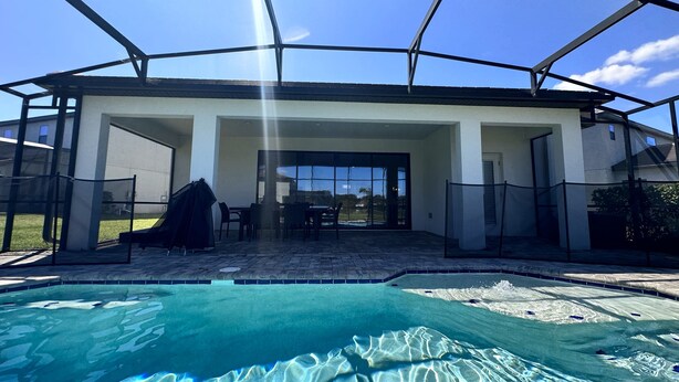 A covered outdoor pool area with a patio and seating. - Balmoral Resort-210bp 4 Bedroom Home by RedAwning (Haines City)