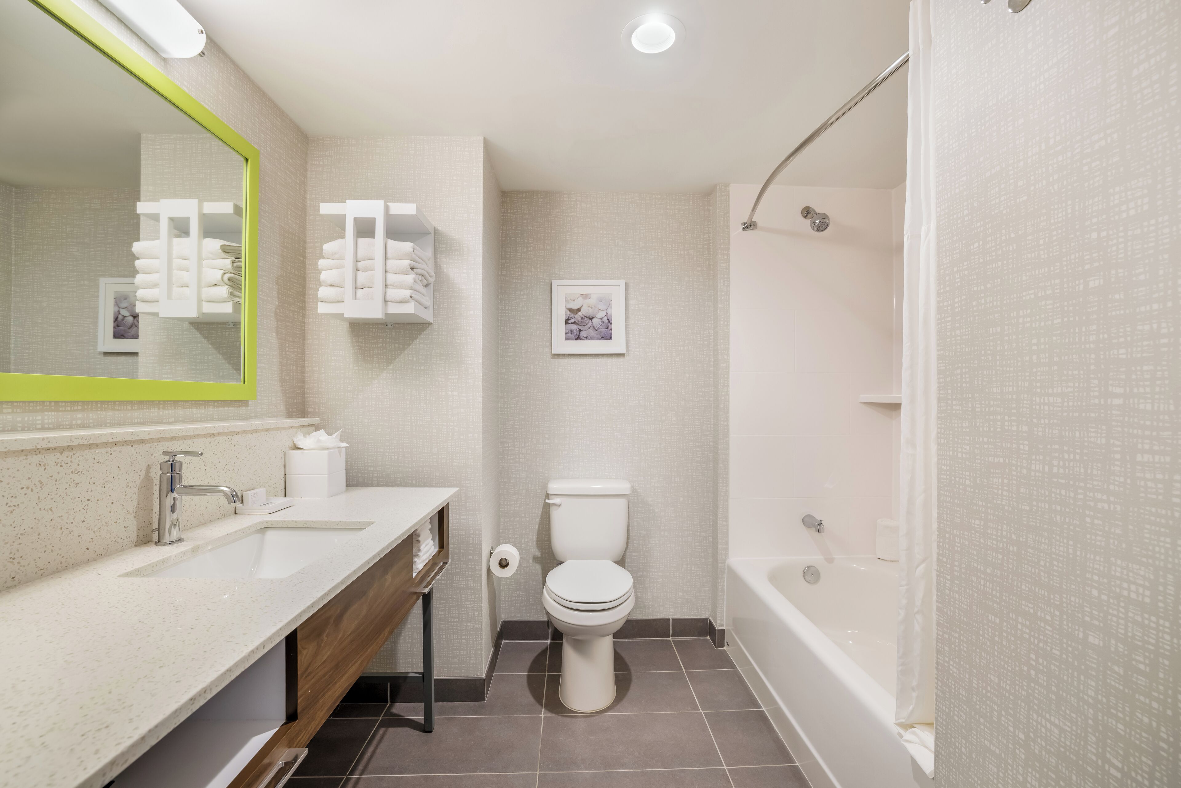 Une salle de bain moderne avec un lavabo, des toilettes et une baignoire.