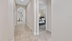 A hallway with a tiled floor, white walls, and an arched ceiling. - Balmoral Resort-222mcv 4 Bedroom Home by RedAwning (Haines City)