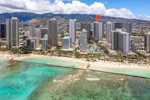 A coastal cityscape with high-rise buildings, a beach, and a clear view of the ocean.