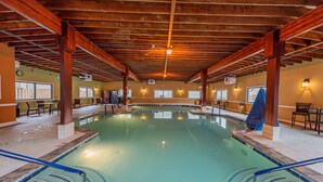 An indoor swimming pool with wooden beams, clear water, and a tiled edge. - Renovated 1st Fl 2BR/2BA, priv patio! Indoor/outdoor Pool; steps to BEACH & Dine (Ocean City)