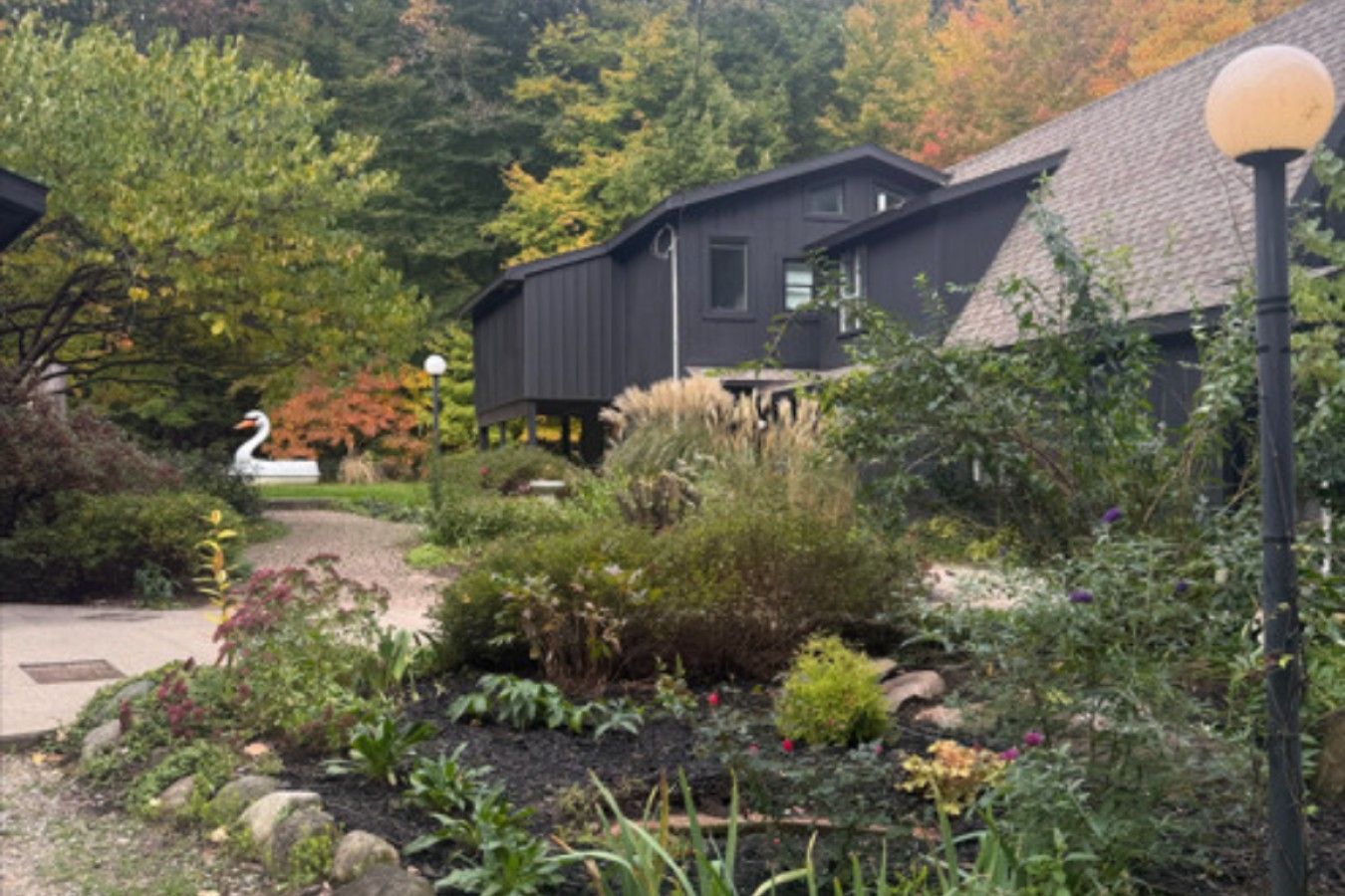 A residential area with a garden, a bird sculpture, and a building with a dark exterior.