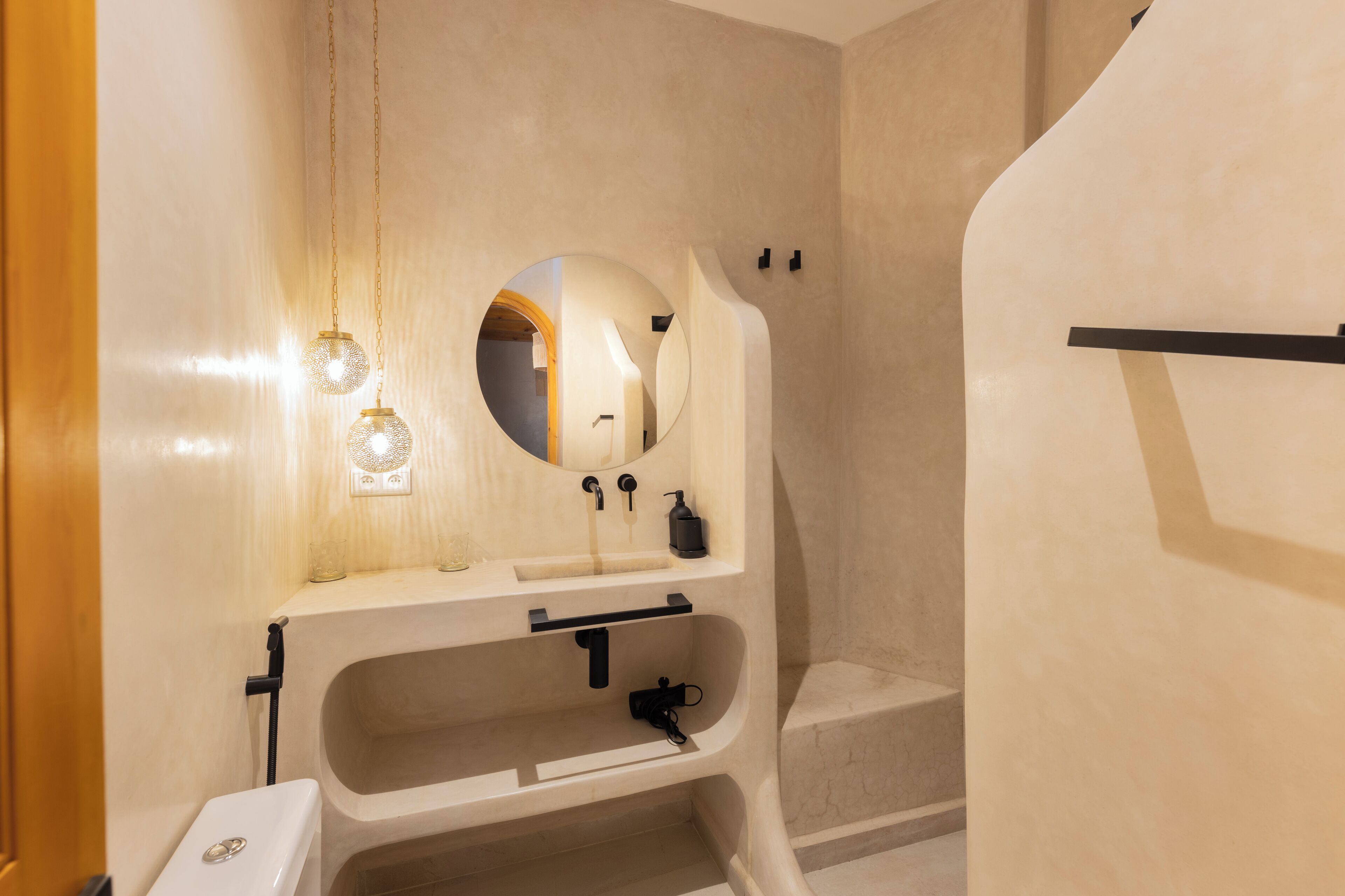 Un baño moderno con un espejo grande, un lavamanos y una bañera.