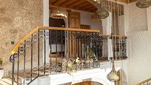 A balcony with wrought iron railings, potted plants, and hanging light fixtures.