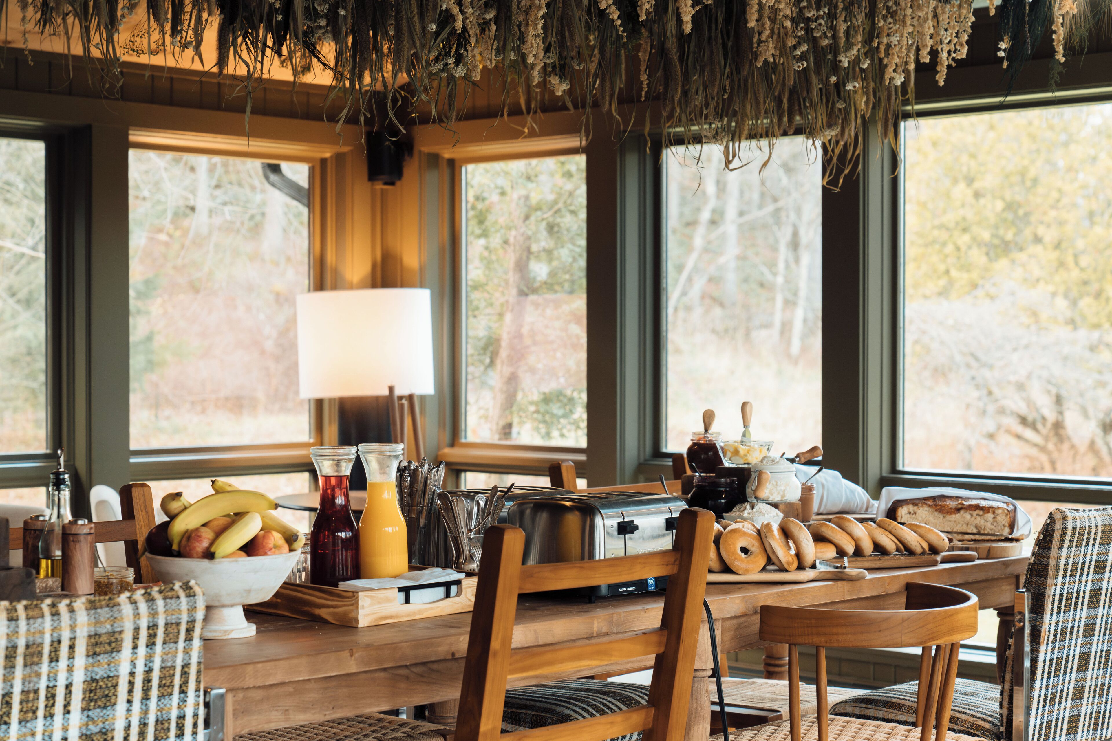 A breakfast table with various food items, a toaster, and a bowl of fruit.