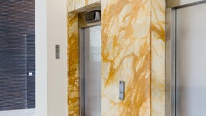 En moderne elevator med marmorvægge og metalfinish.