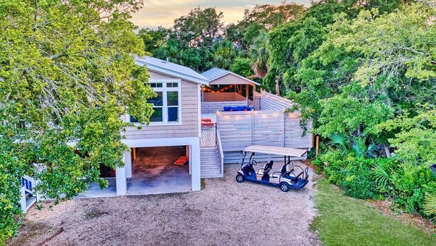 A house with a covered deck, a garage, and a golf cart. - Island Adventures Await at the Pet Friendly “Boathouse SGI” (Saint George Island)