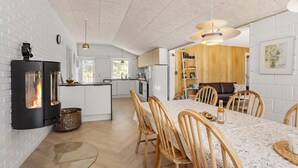 A modern kitchen with a central island, wooden chairs, and a dining table. - Cozy home in ålbæk with WiFi (Ålbæk)