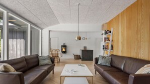 A modern living room with leather sofas, a white coffee table, and a fireplace. - Cozy home in ålbæk with WiFi (Ålbæk)