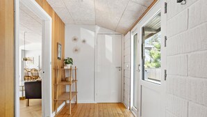 A hallway with wooden flooring, a white door, and a window with a view of the outside. - Cozy home in ålbæk with WiFi (Ålbæk)
