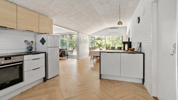 A modern kitchen with white cabinetry, a built-in oven, and a refrigerator. - Cozy home in ålbæk with WiFi (Ålbæk)