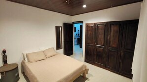 A bedroom with a bed, a wardrobe, and a small round table. - Comfort in the Jungle (Sámara)