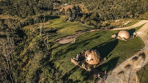 A dome-shaped building surrounded by lush green fields and hills. - Kairos Glamping - Rancho Queimado - SC (Rancho Queimado)