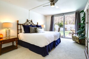A bedroom with a large bed, a nightstand, a ceiling fan, and a view of the outdoors through a sliding glass door. - 55 + Indian Wells Retreat: Private Pool & Spa! (Indian Wells)