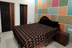Cozy retreat with a patterned bedspread, wooden headboard, and bedside table.