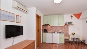 A compact kitchen with a flat-screen TV, a coffee maker, and a microwave. - Stunning apartment in Privlaka with WiFi (Privlaka)