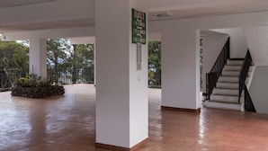 Un vaste espace intérieur doté d’un escalier et d’un panneau indiquant les appartements numéros 2, 1 à 4, 7 à 14 et 1 à 6.