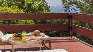 A wooden bench with a table and a bowl of fruit and juice. - Holiday duplex in Madeira - Matur I (Agua De Pena Machico)